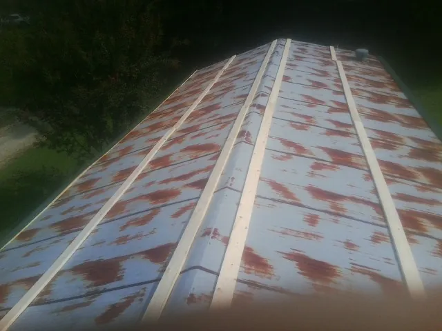 Rusted metal roof panels with new wood purlins before replacement — Storm Damage Roof Repair in Dalton by Roofing Brothers